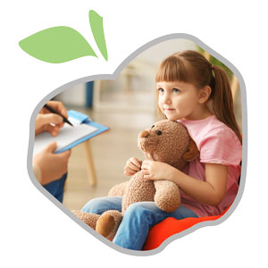 little girl holding bear with psychologist